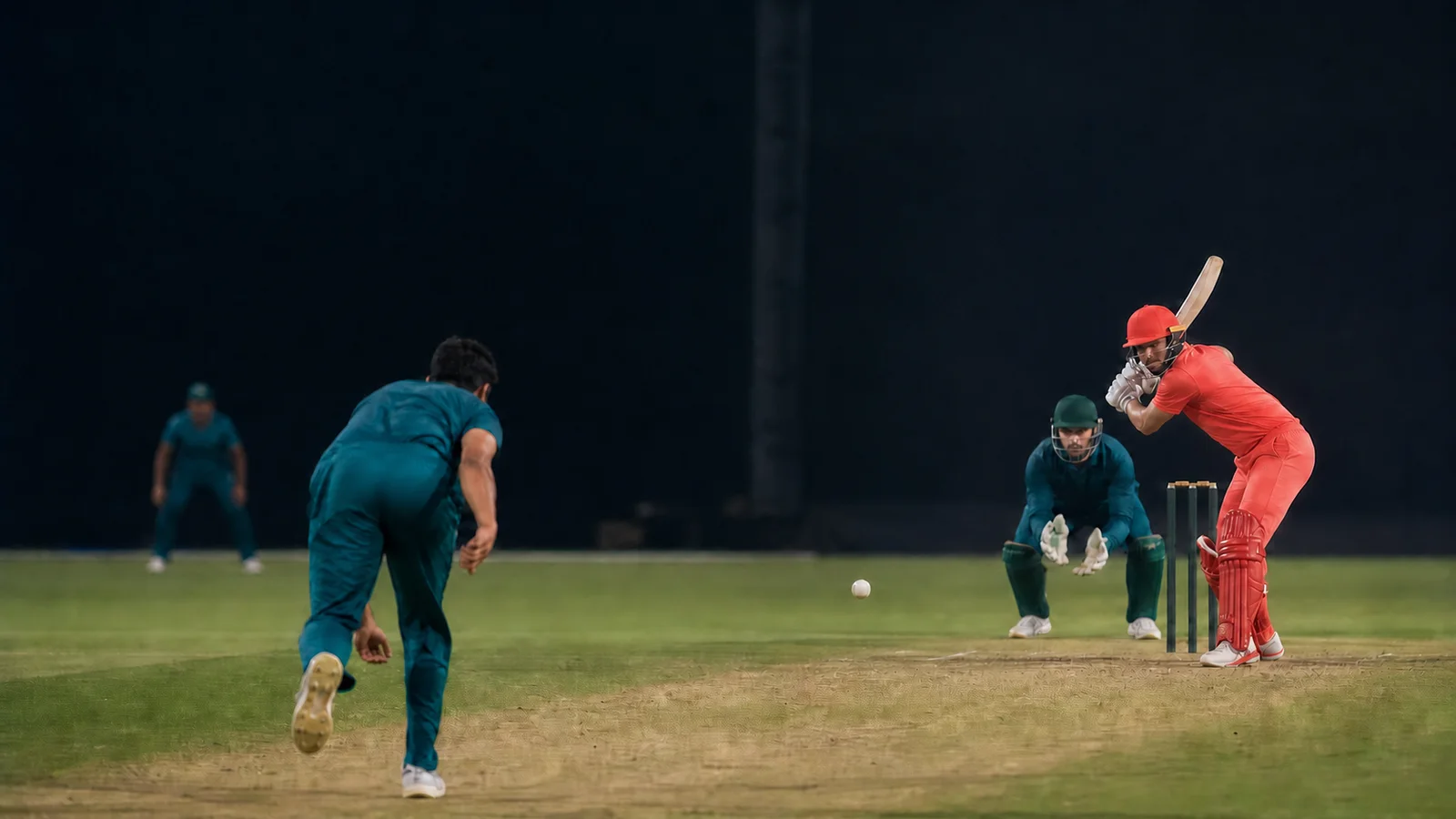 A fictional fast bowler delivers a white ball to a fictional batter during a floodlit Super Over