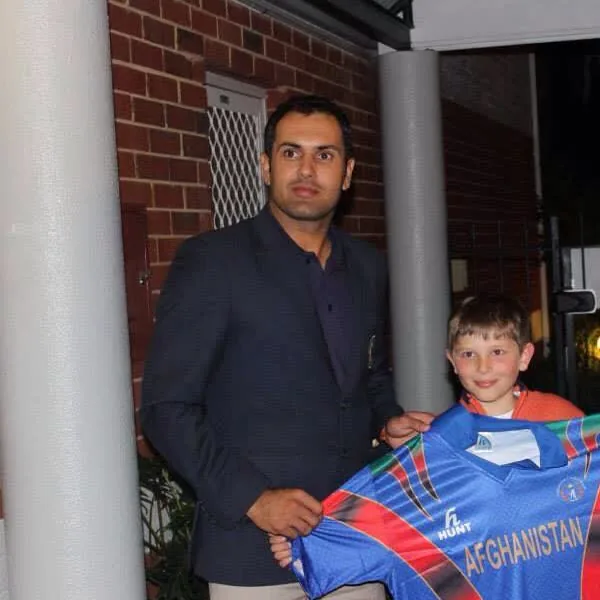 Mohammad Nabi portrait in Formal cricket-tour jacket beside an Afghanistan playing shirt